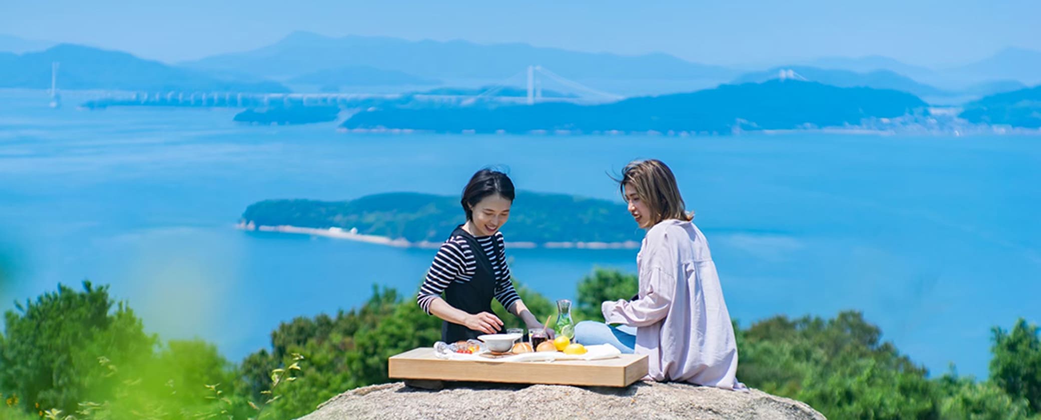 瀬戸内海を背景に食事をする写真