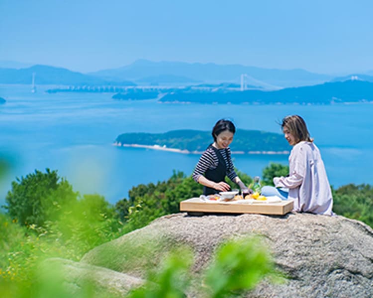 瀬戸内海を背景に食事をする写真